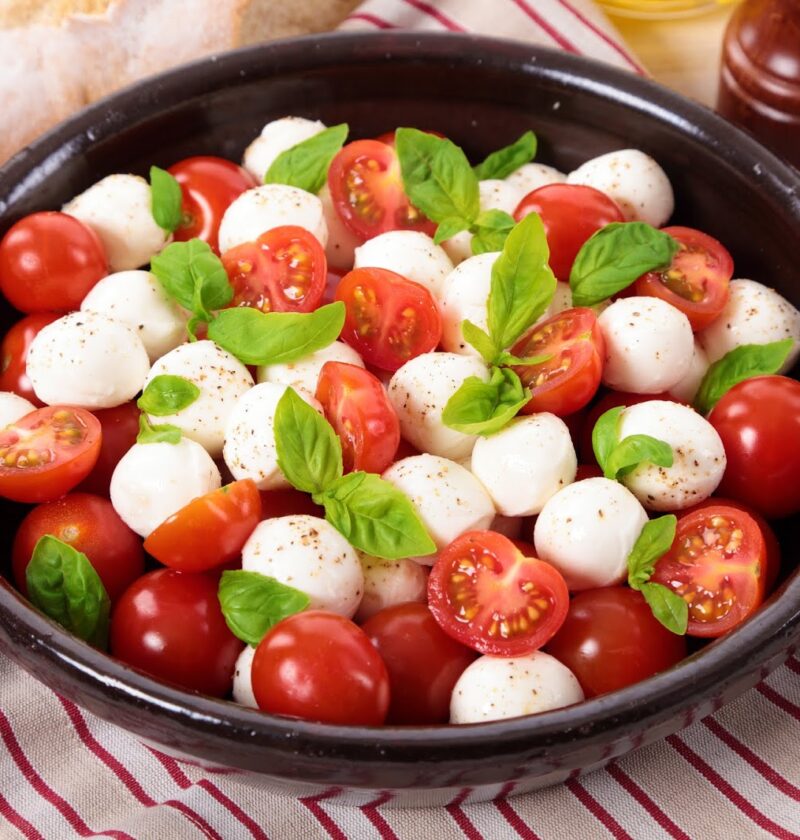 Caprese Salad With Mozzarella, Cherry Tomatoes And Basil Leaves